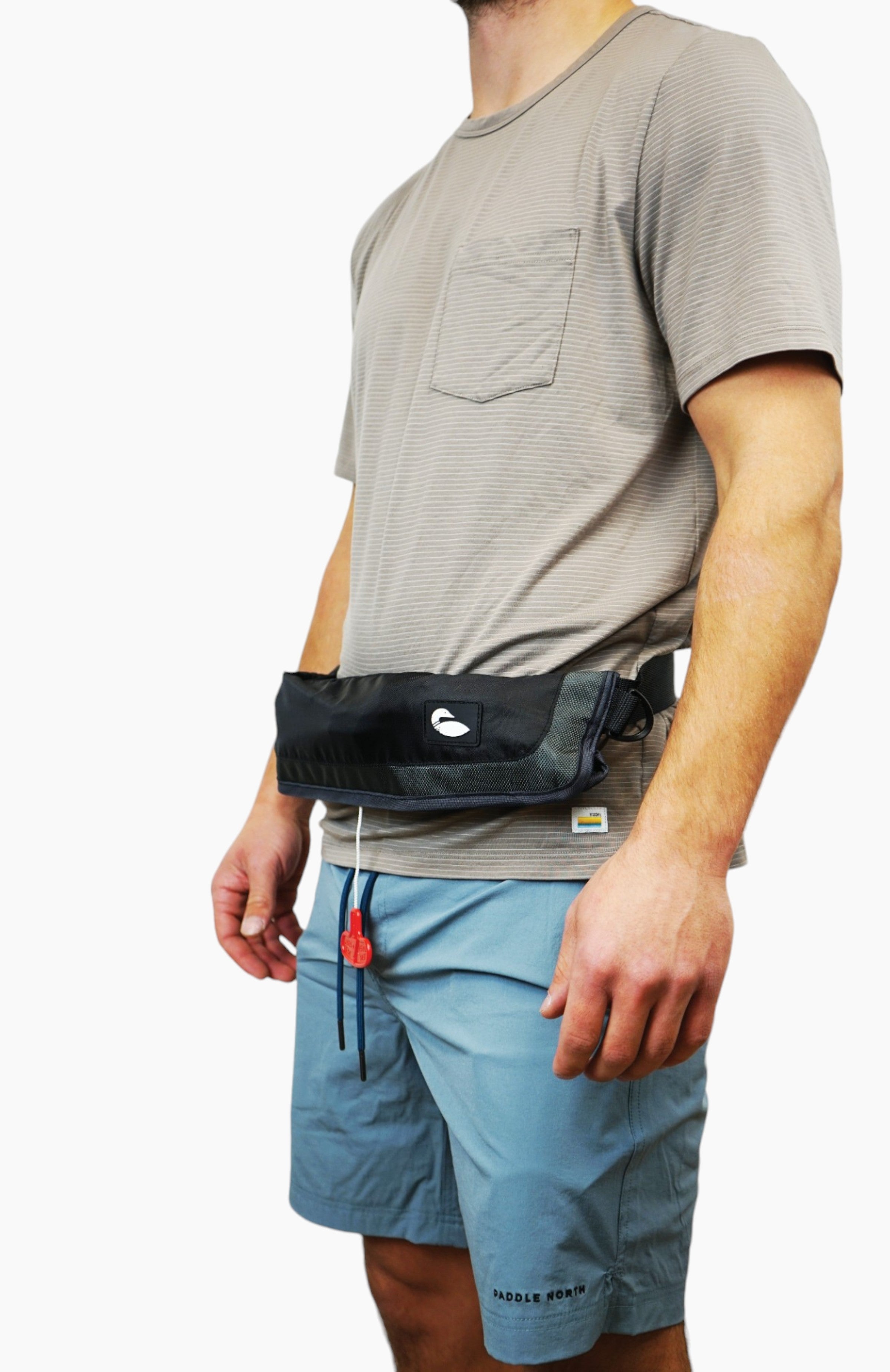 Water accessories: man wearing an inflatable life jacket stored in a black bag worn like a belt.