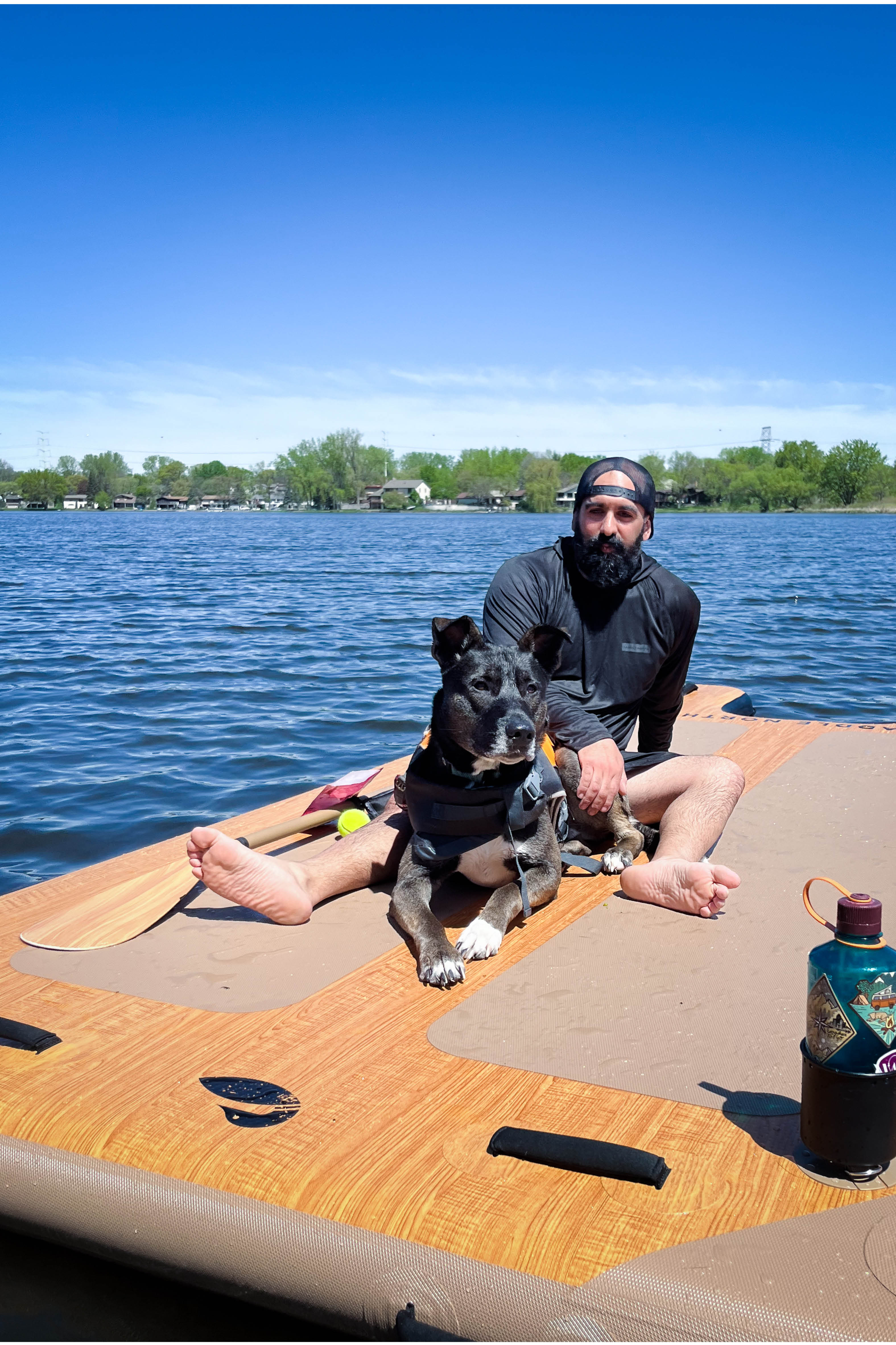 Person using an inflatable dock with a ramp beside their dog.