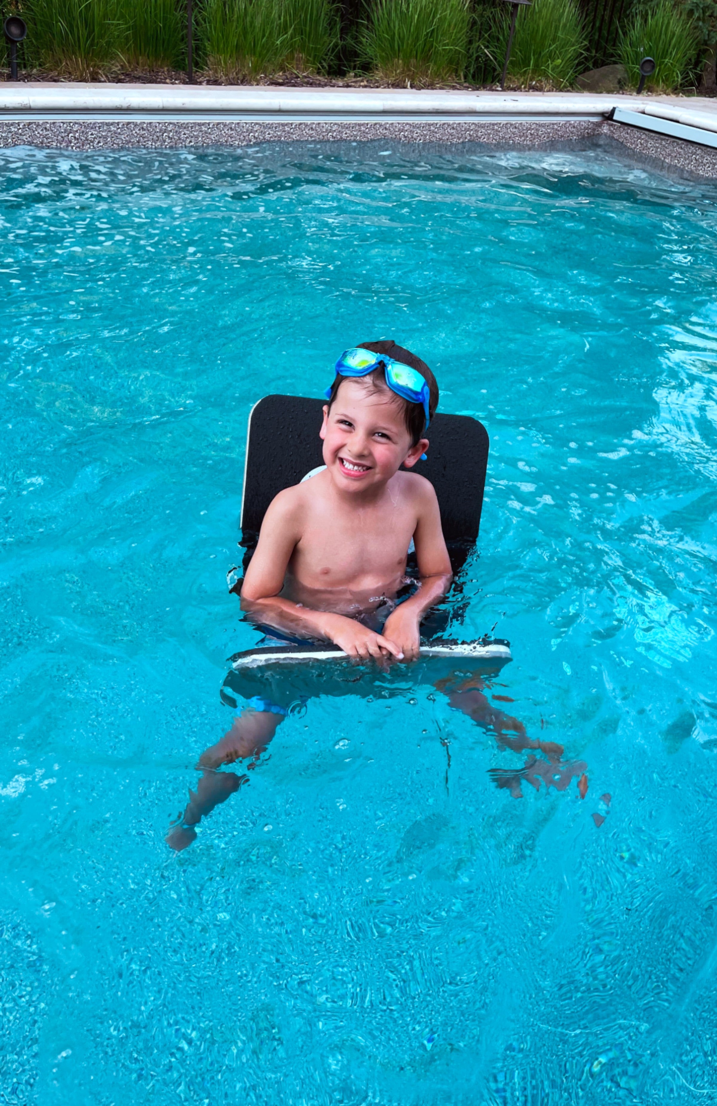 Water accessories: Child playing in a pool using the lake float saddles.