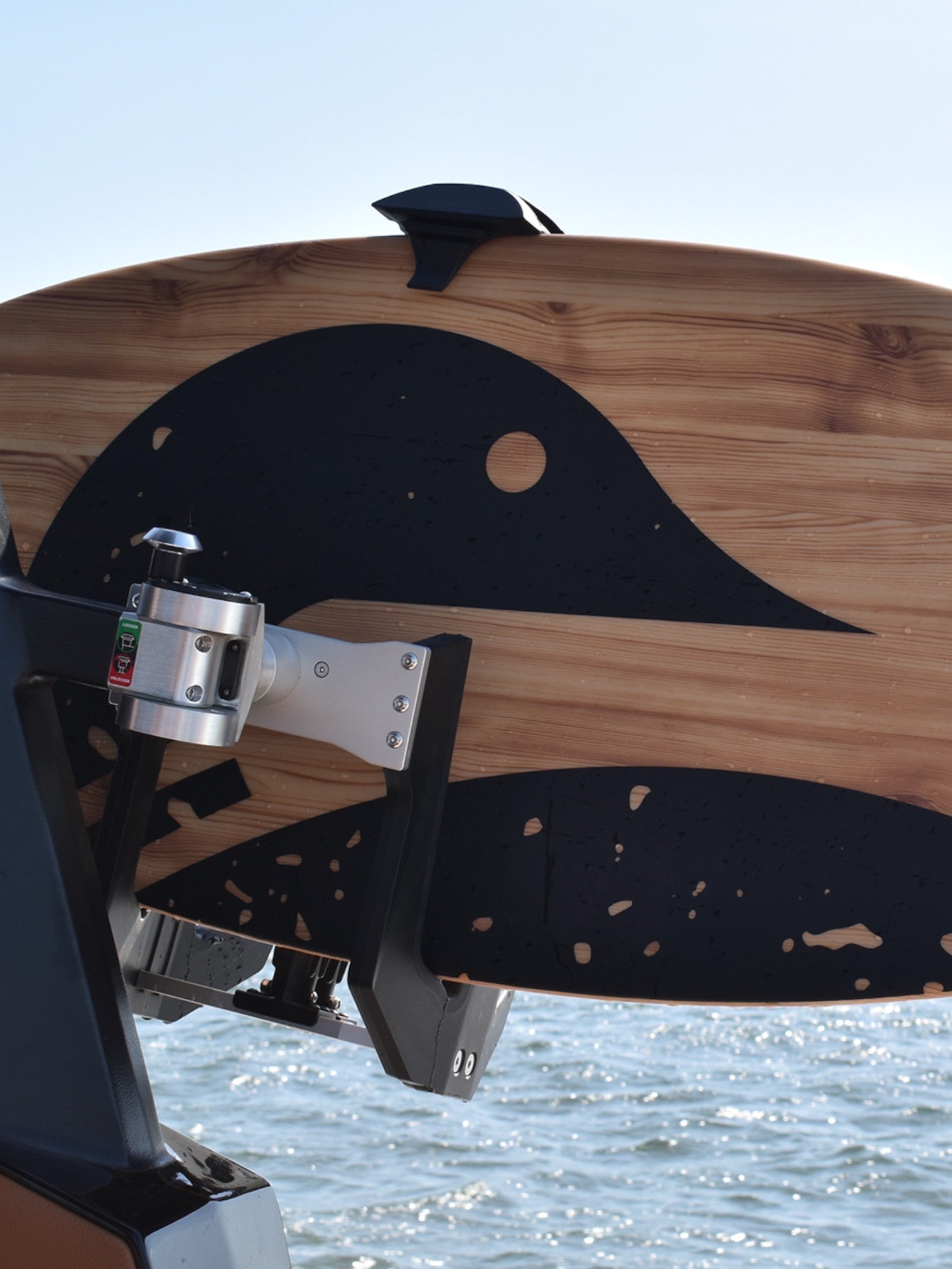 Lake surfer being held on a boat on the water.