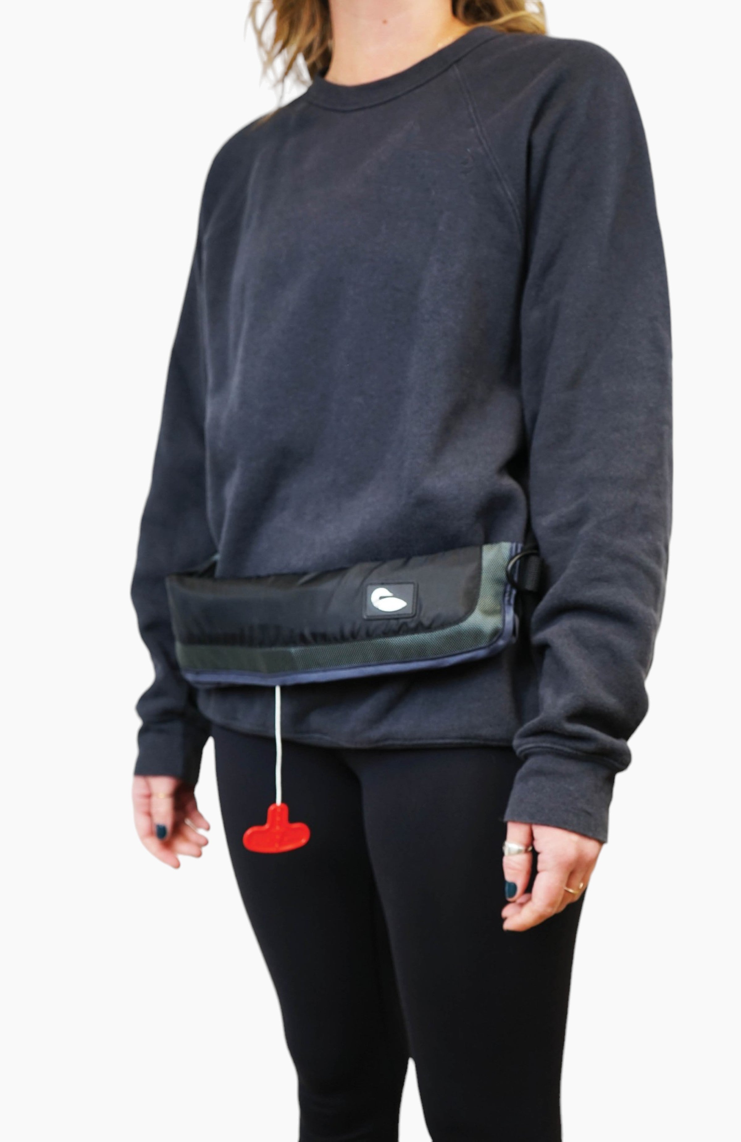 Water accessories: woman wearing an inflatable life jacket stored in a black bag worn like a belt.
