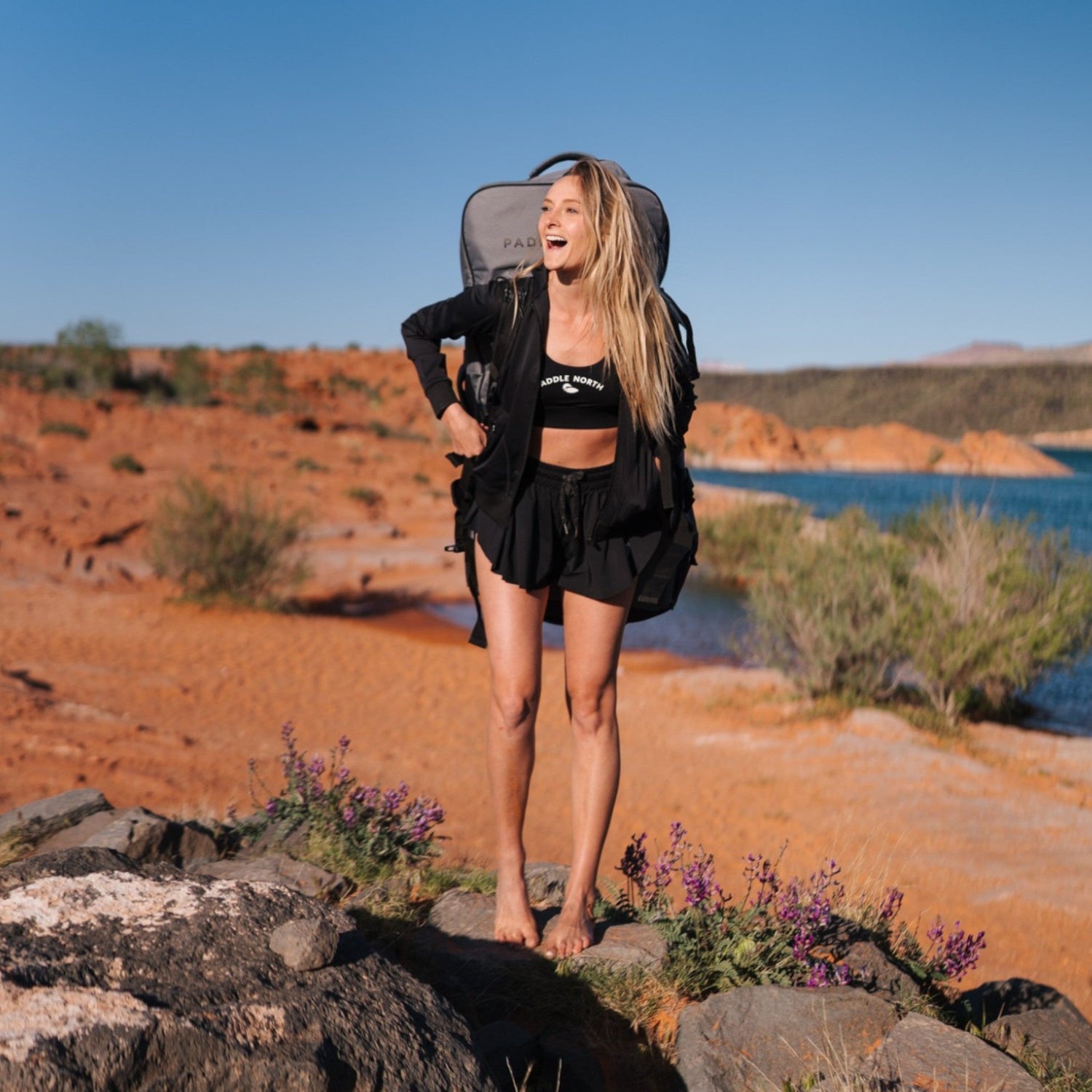 woman carrying paddle north backpack in the desert