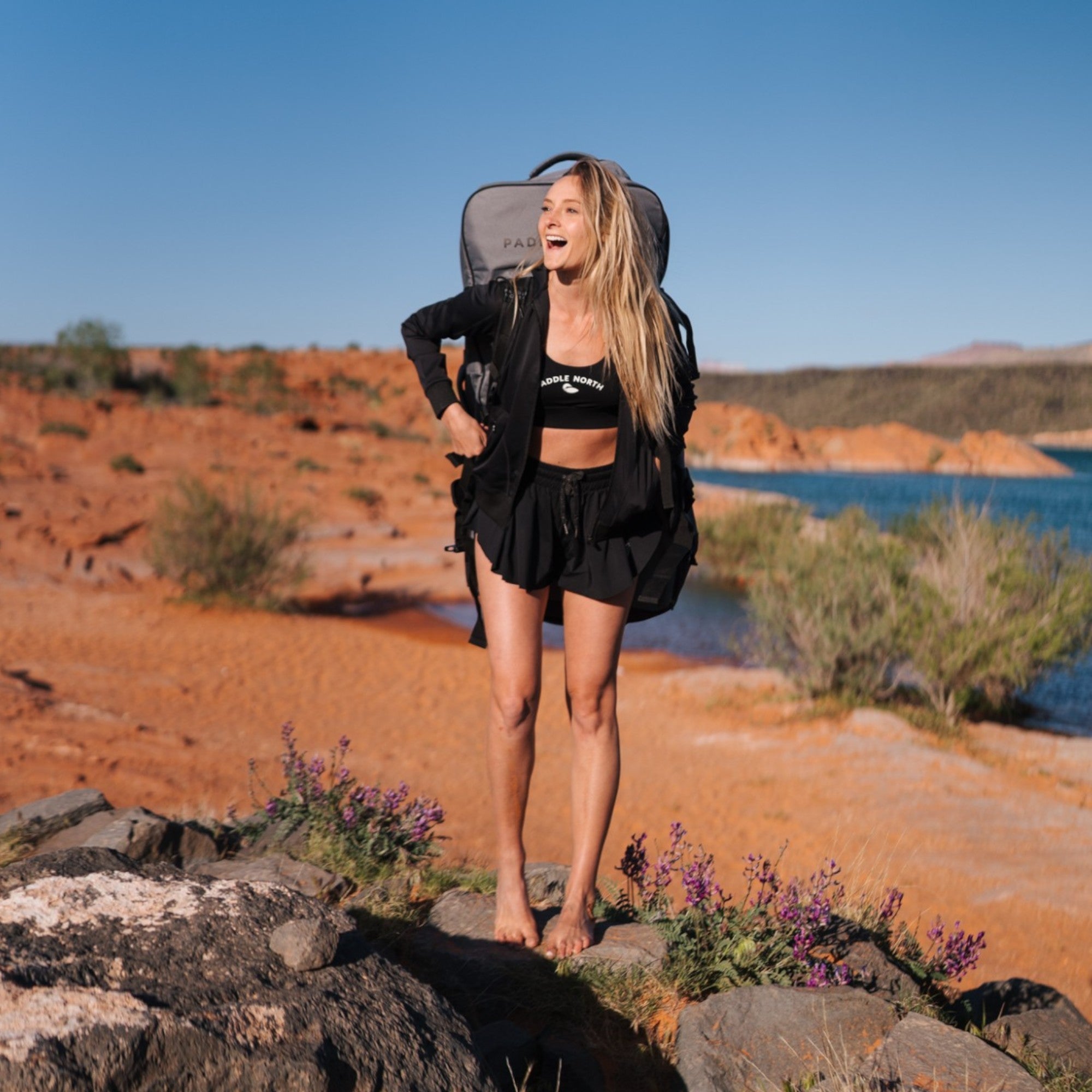 woman carrying paddle north backpack in the desert