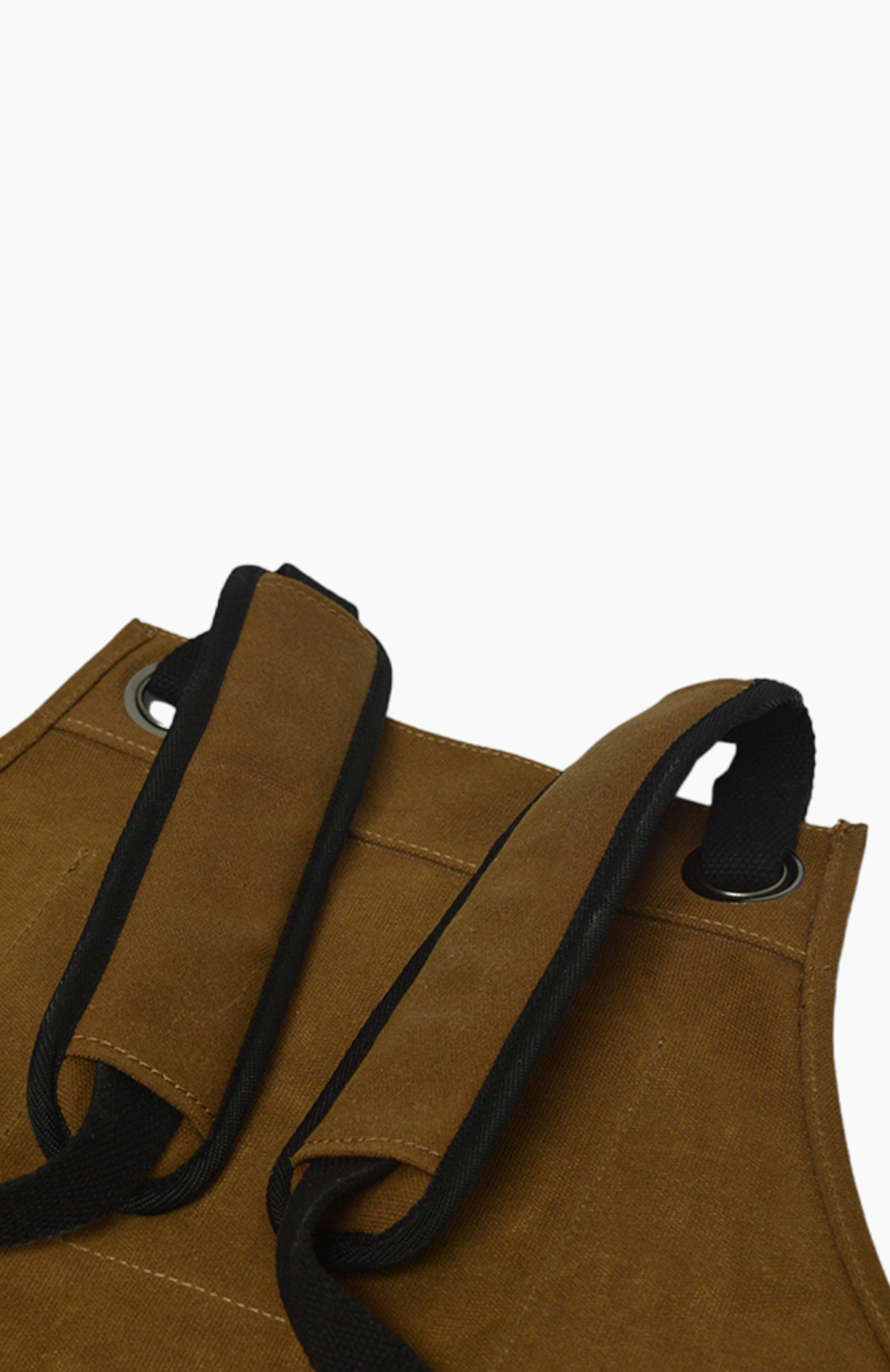 Close up of the padded back straps on a brown leather apron.
