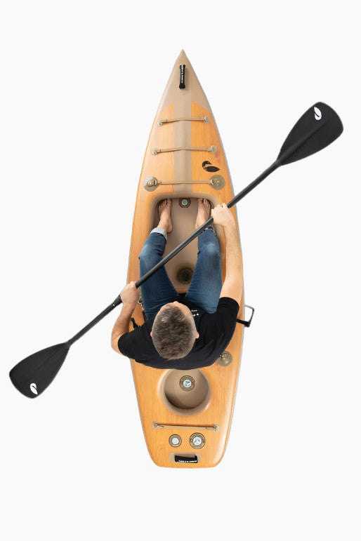 Person sitting in an inflatable kayak holding a black paddle.