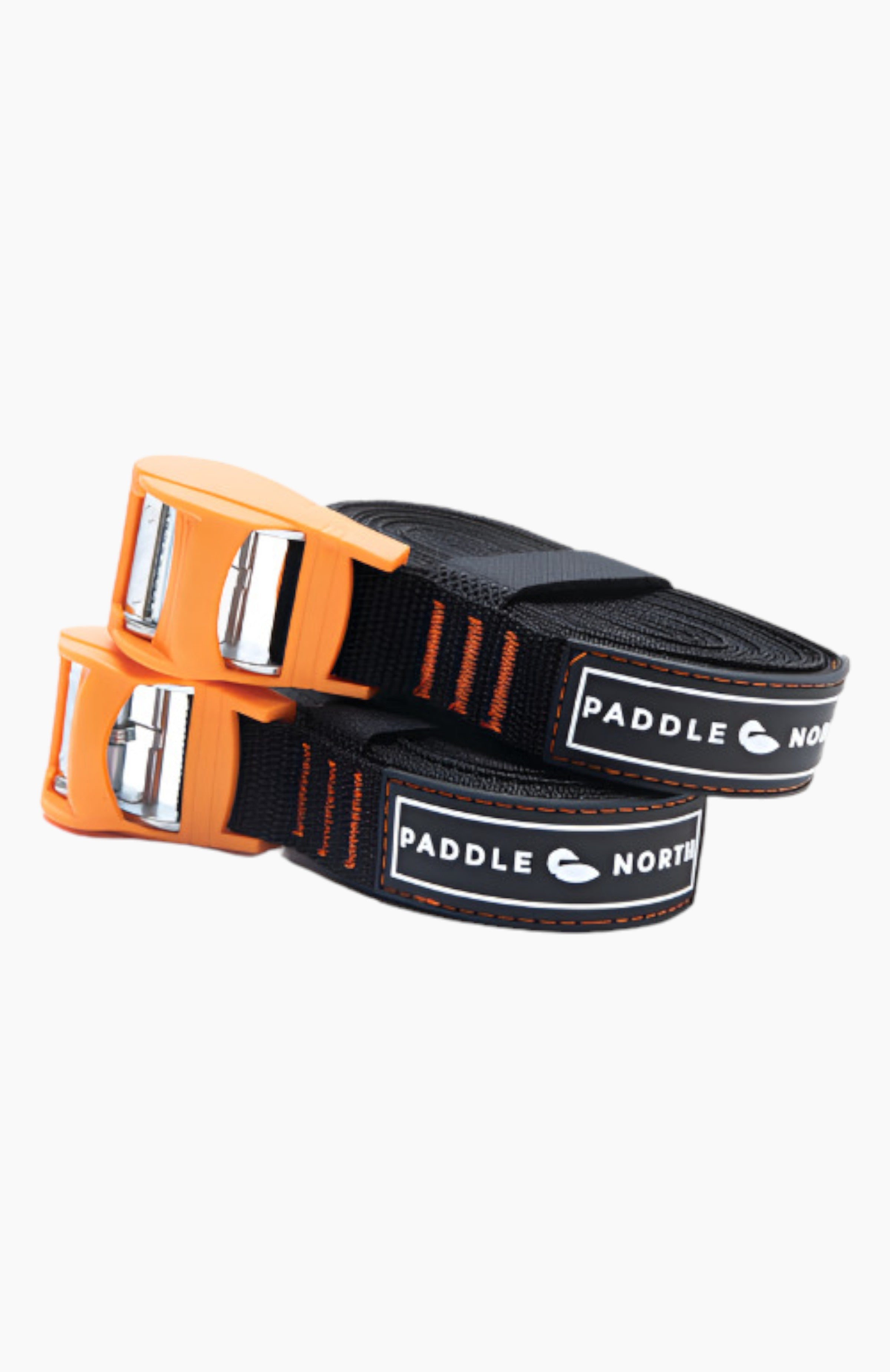 Black straps with orange clasps rolled up stacked on top of one another.