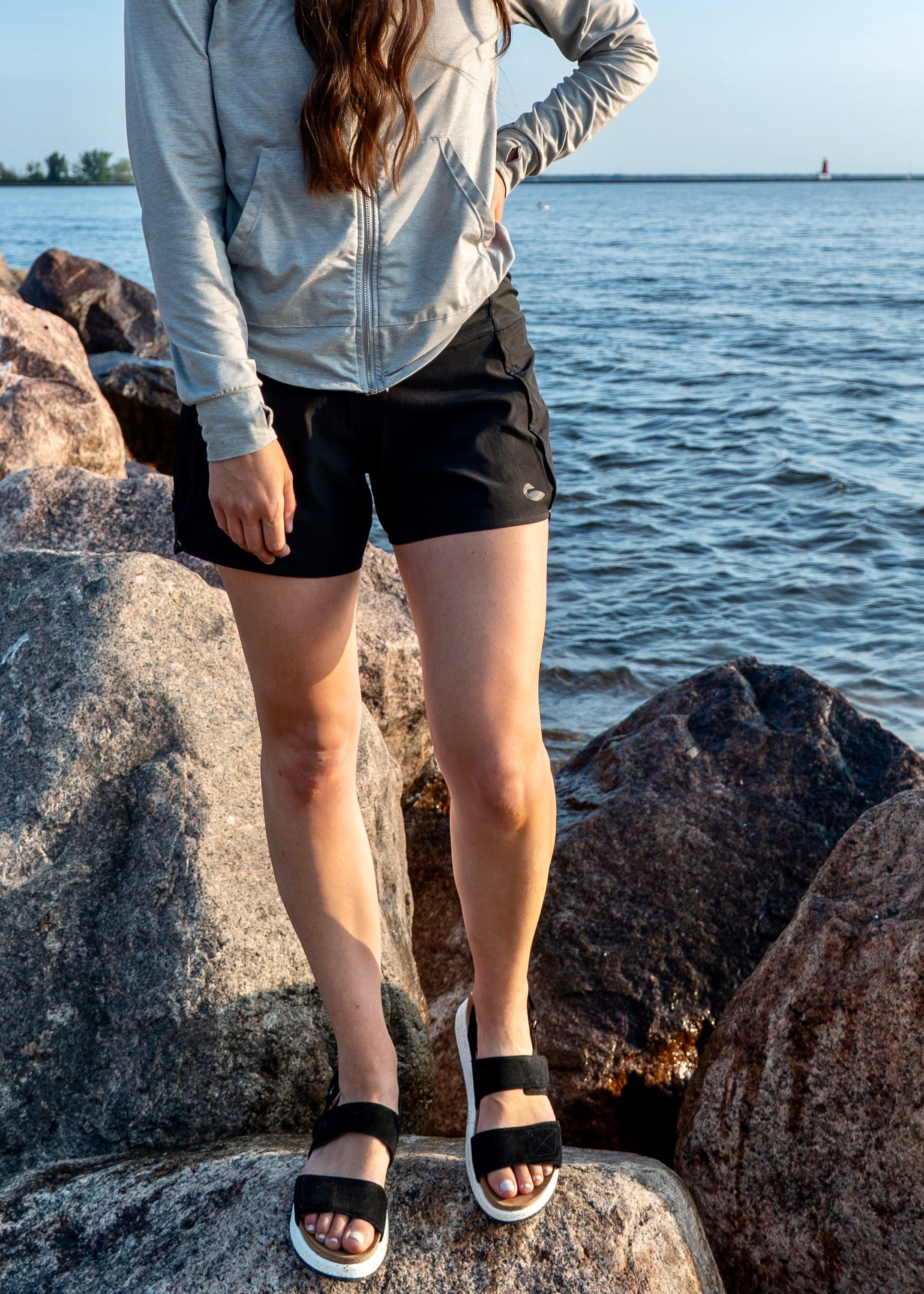 Close up photograph of black shorts along a rocky shoreline.