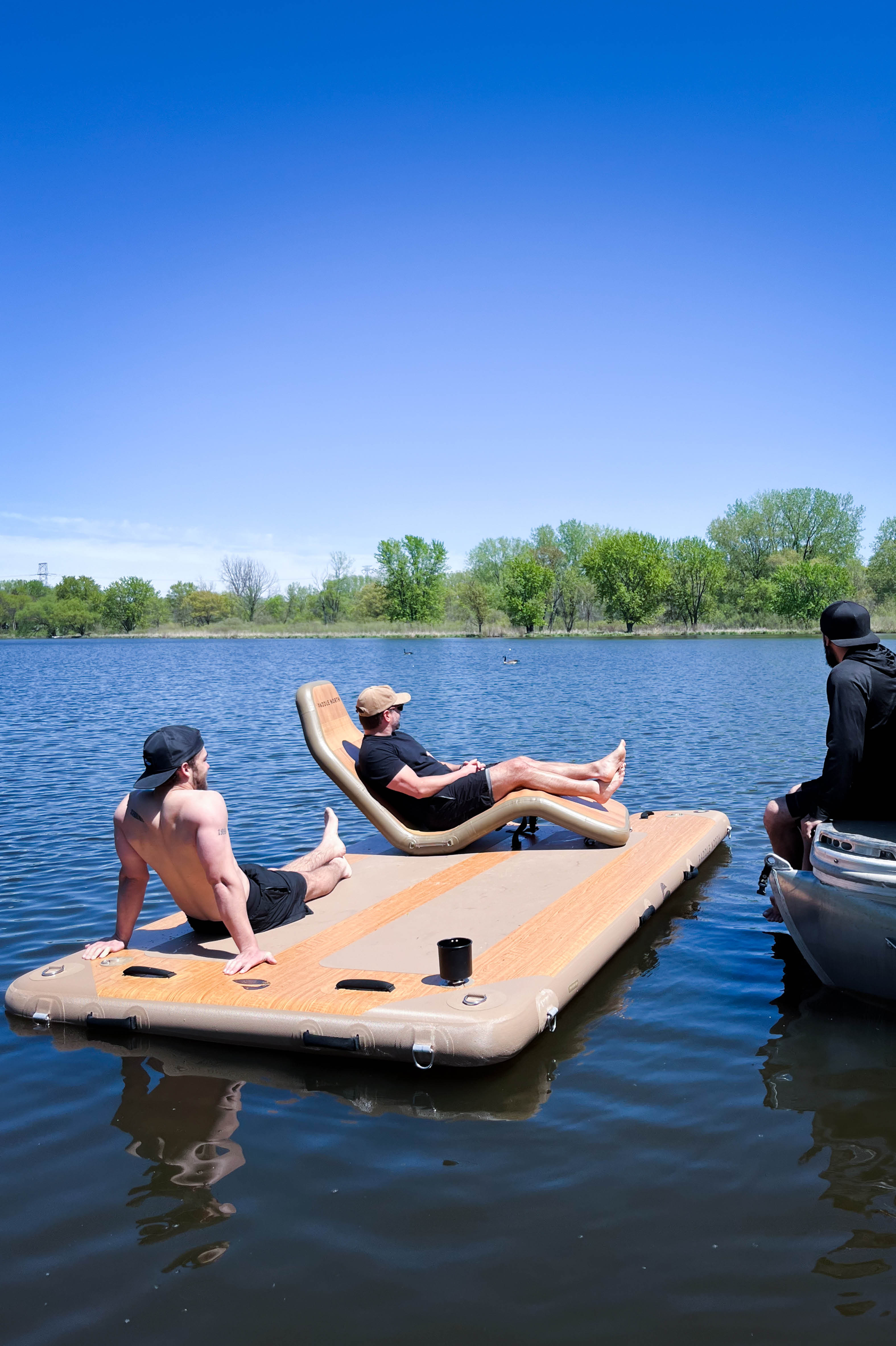 People sitting on an inflatable dock in the water.