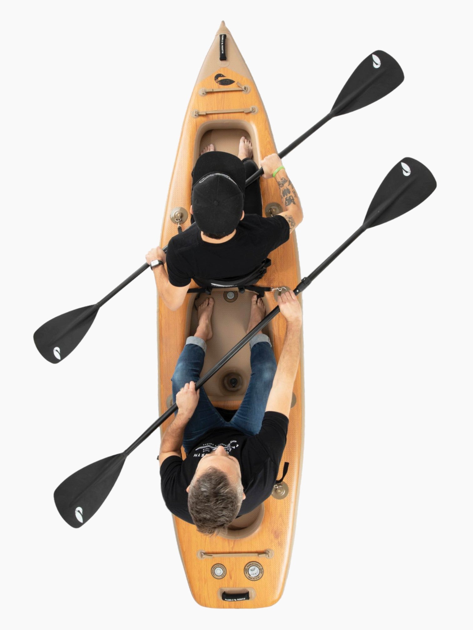 Two people sitting in the double inflatable kayak with black paddles.