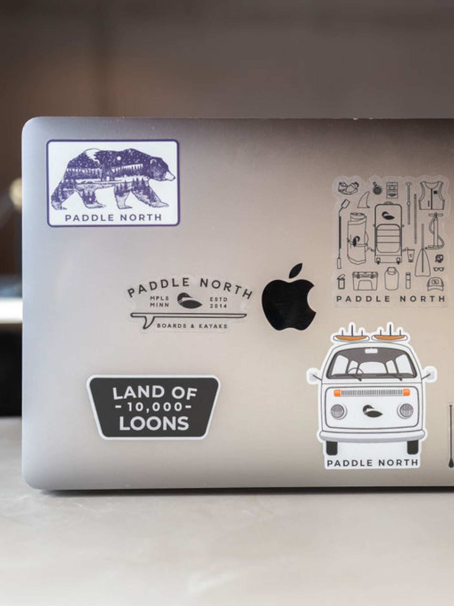 Macbook Laptop with assorted paddle north stickers on it.