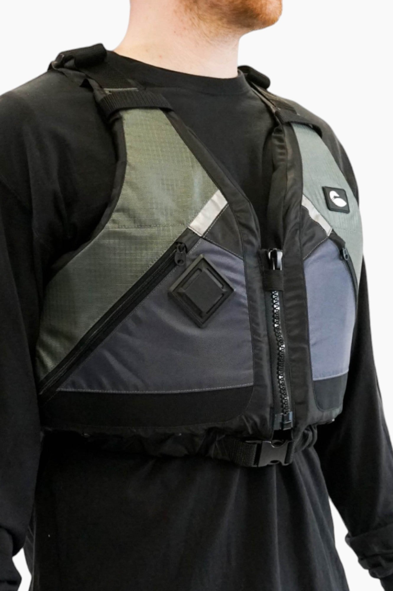 Person wearing a green and grey life vest with black zippers.