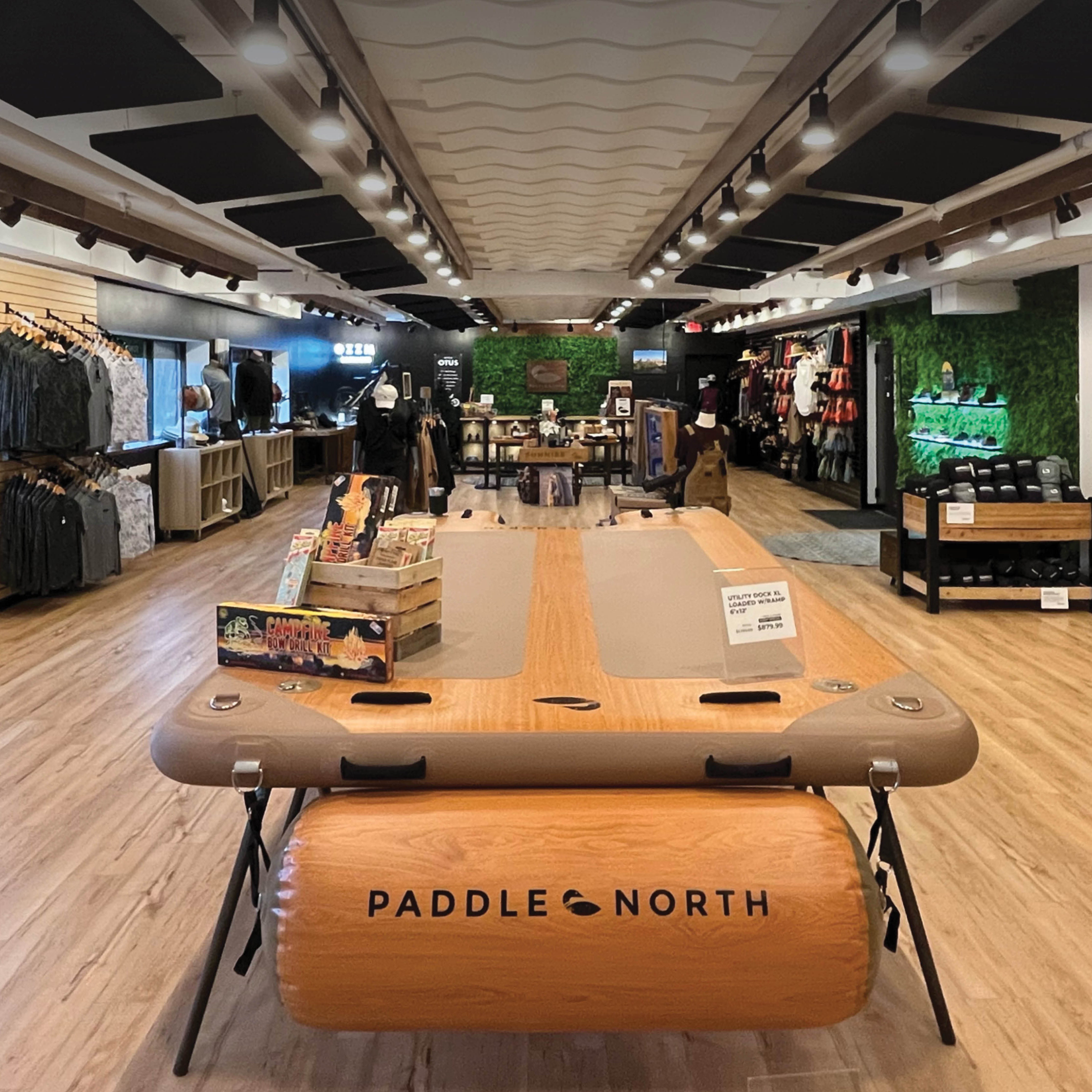 Inside of Paddle North Minnesota store with various paddle boards, floats, apparel, and outdoor gear for sale.