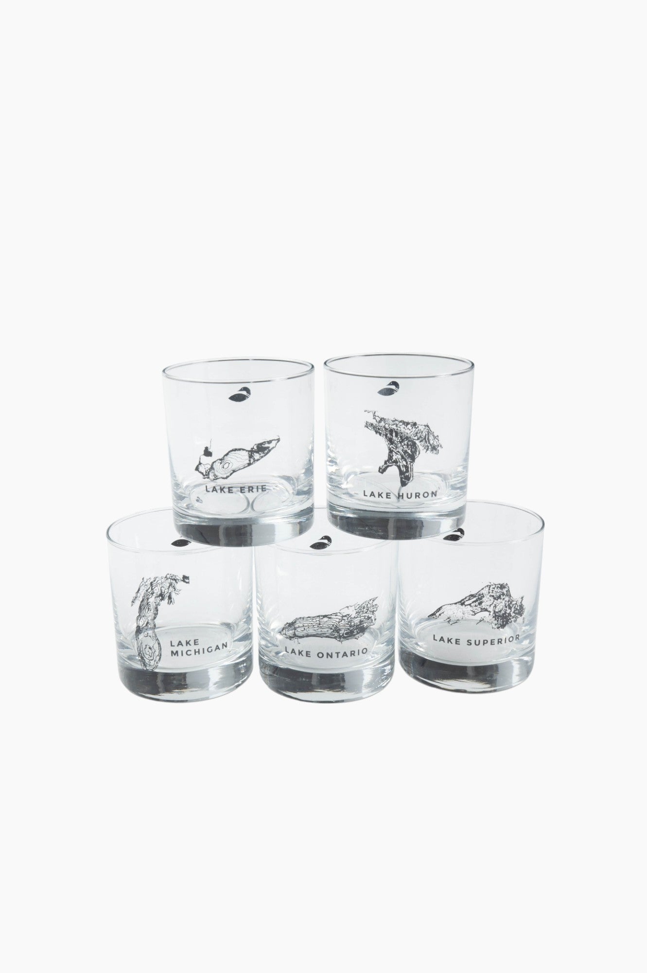 Clear drinking glasses stack on top of one another, each with a printed great lake on it.