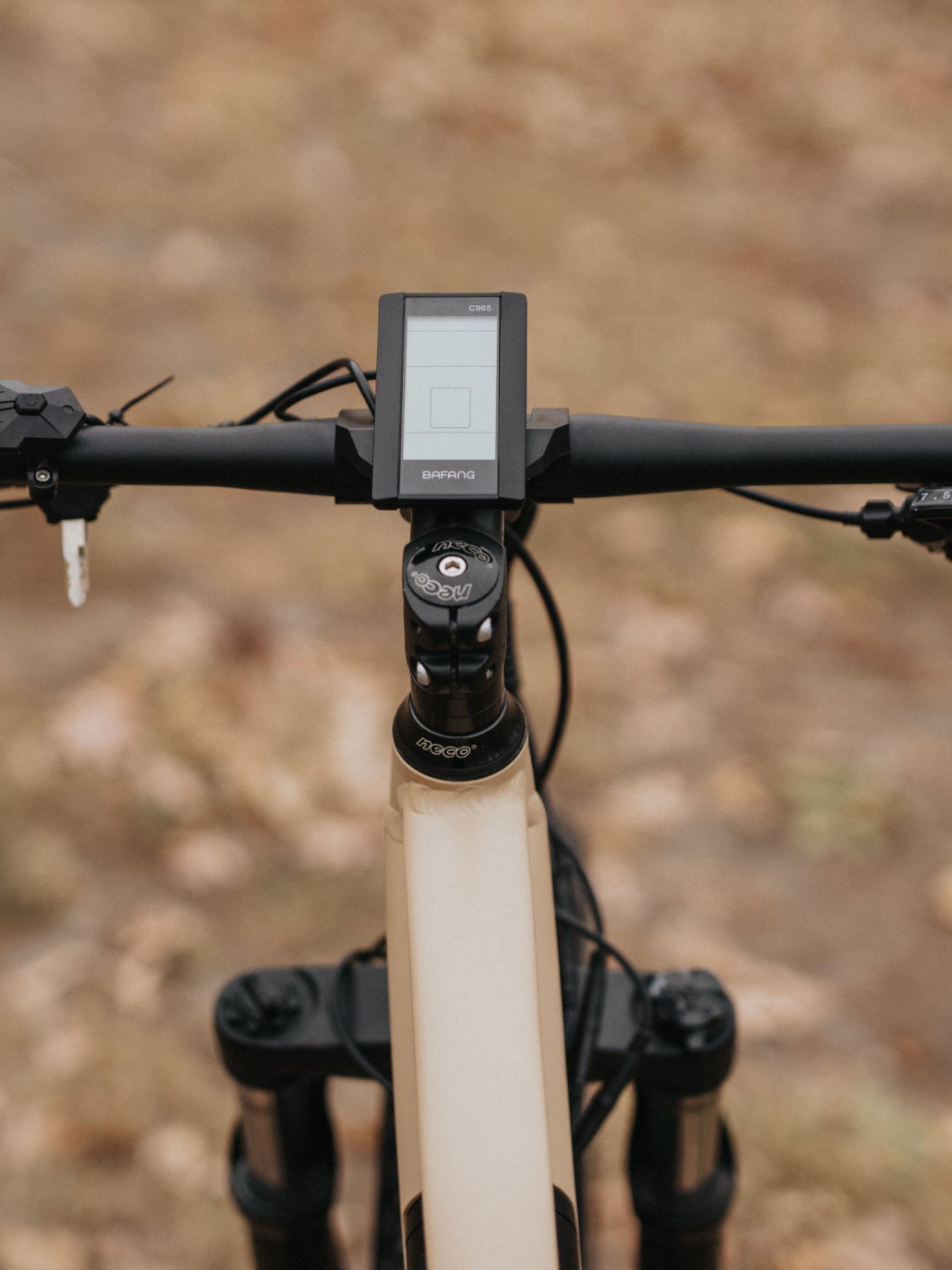 Close up of screen on tan electric bike between the handlebars.